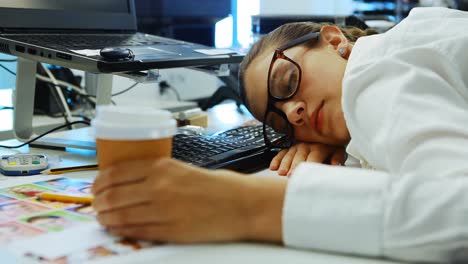 Female-graphic-designer-sleeping-at-desk
