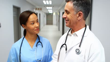Doctors-interacting-with-each-other-in-corridor