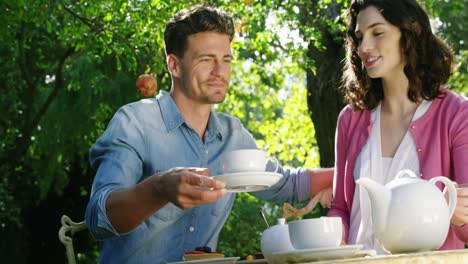 Man-serving-tea-to-woman-in-park