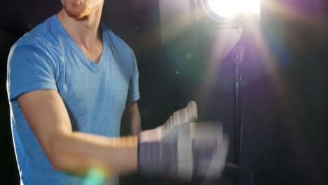 Male-photographer-adjusting-flashlight-during-shoot