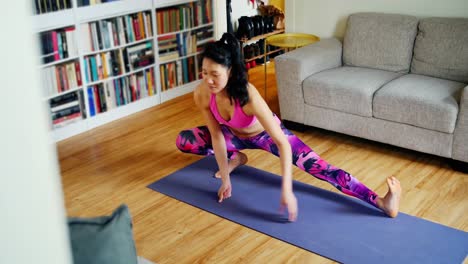 Schöne-Frau,-Die-Yoga-Im-Wohnzimmer-Praktiziert