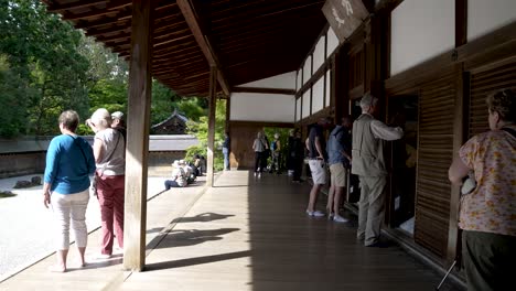 Ausländische-Touristen-Auf-Der-Veranda-Des-Ryoanji-Tempels-An-Einem-Sonnigen-Tag