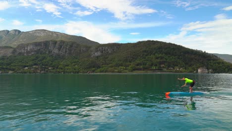 Dos-Jóvenes-Franceses-Nadan-A-Través-Del-Lago-Annecy-En-Una-Tabla-De-Remo.