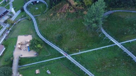 Drone-shot-in-bird-eye-view-style-of-bobsleigh-on-wheels-in-Swiss-mountains