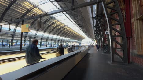 POV-Caminando-Por-El-Andén-De-La-Estación-Junto-A-Las-Escaleras-Mecánicas-En-La-Estación-Central-De-Amsterdam