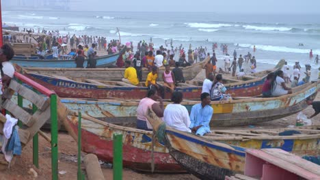 Gente-Reunida-En-La-Playa-Con-Un-Barco-Pescador-Y-Un-Vendedor.