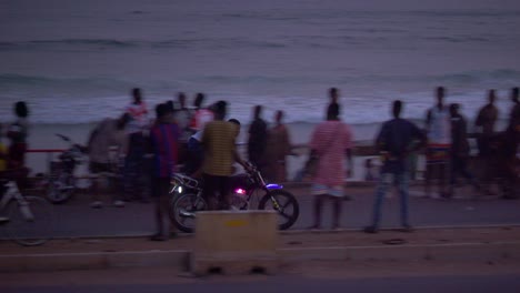 Reiter-Macht-Akrobatik-Auf-Dem-Motorrad-Auf-Einer-Straße-In-Strandnähe-Mit-Verkehr-Und-Fußgängern