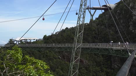 Los-Turistas-Disfrutan-De-Las-Vistas-Del-Puente-Elevado-Mientras-Los-Teleféricos-Pasan-Por-Encima-De-Langkawi.