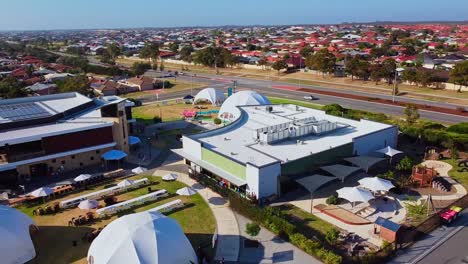 Aerial-Orbit-Over-Modern-Church-Buildings-With-White-Event-Dome-Tents-On-Lawns