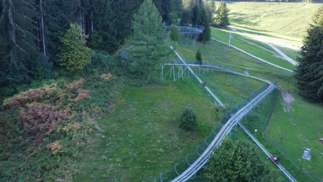 Toma-De-Drones-De-Bobsleigh-Sobre-Ruedas-Subiendo-A-Una-Colina-En-Las-Montañas-Suizas