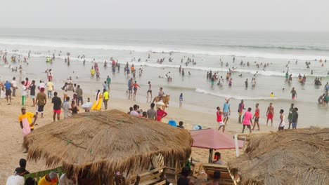 Gente-Reunida-En-La-Playa-De-Sakumono-Jugando-Y-Nadando-En-El-Agua-Del-Océano