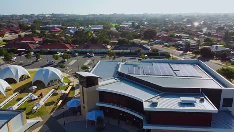 órbita-Aérea-Sobre-Un-Moderno-Edificio-De-Iglesia-Con-Paneles-Solares-Y-Tiendas-De-Campaña-Con-Cúpula-Blanca