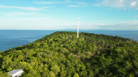 Paso-Elevado-Aéreo-Hermosa-Y-Pacífica-Colina-Verde-Vibrante-Con-Un-Molino-De-Viento-En-La-Cima-De-Koh-Tao,-Tailandia