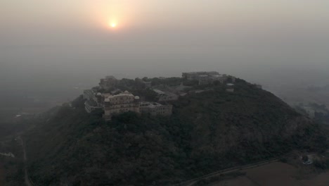 Cámara-Panorámica-Con-Vista-Aérea-De-Drones-Avanzando-Con-El-Sol-Detrás-Y-Palacios-En-La-Colina