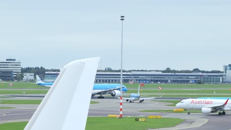 Toma-En-Cámara-Lenta-De-Un-Avión-Despegando-Mientras-Otros-Avanzan-Sobre-Las-Pistas-De-Rodaje