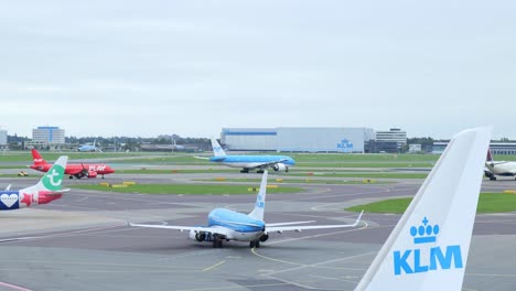 Tractor-Remolcador-Empujando-Hacia-Atrás-Un-Avión-KLM-Mientras-Otro-Avión-Sale