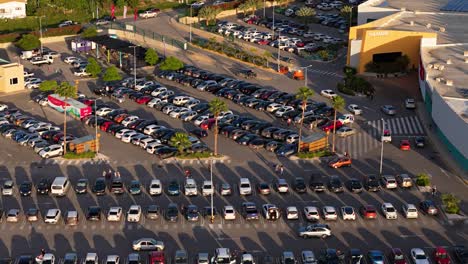 Los-Coches-Entran-Buscando-Aparcamiento-En-Un-Concurrido-Centro-Comercial-Al-Atardecer.