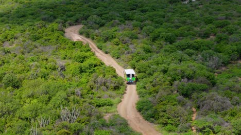 Un-Recorrido-En-Coche-Todoterreno-Recorre-Un-Sinuoso-Camino-De-Tierra-Arenoso-En-Un-Paisaje-Tropical-Caribeño