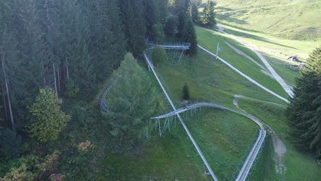 Drone-shot-of-bobsleigh-on-wheels-on-track-coming-downfrom-the-hill-in-Swiss-mountains