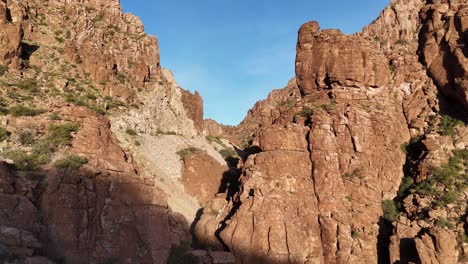 Drone-Panning-up-Revealing-Jagged-mountain-walls-and-Rock-Spires-Highway-60-in-Superior,-Arizona