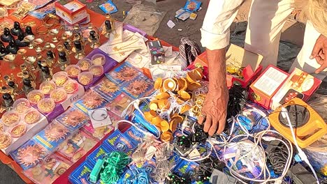 Wide-shot,-a-shopkeeper-is-selling-LED-lights-and-decorative-lights-for-home-decoration-on-a-street-road