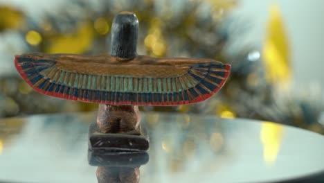 Dreamy-close-up-shot-of-a-Cleopatra-statue-with-wide-open-wings,-hazy-golden-depth-of-field,-ancient,-Egyptian-historical-ruler,-antique-artwork-of-a-goddess,-rotating-360-slow-4K-video-pan-right