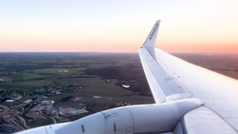 An-airplane-wing-with-a-company-logo-is-bathed-in-the-soft-twilight-hues-of-the-evening-sky---Ryanair-line