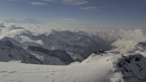 Panorama-Drohnenaufnahme,-Die-Das-In-Sonnenlicht-Getauchte-Rifugio-Quintino-Sella-Kurz-Nach-Einem-Frühlingsschneesturm-Einfängt