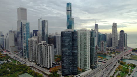 Aerial-view-approaching-the-155-N-Harbor-Drive-building,-cloudy-sunset-in-Chicago,-USA