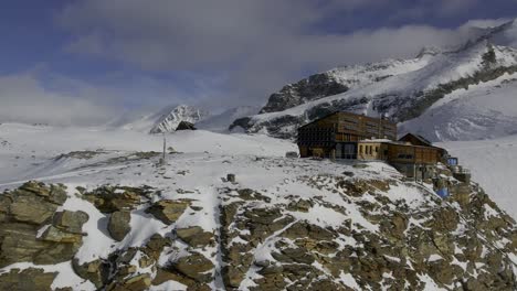 Drone-approaches-Rifugio-Quintino-Sella-al-Felik-with-the-Castore-peak-and-glacier-in-the-background