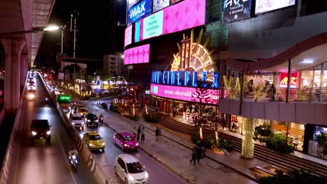 Situación-Del-Tráfico-De-Una-Calle-Muy-Transitada-Frente-A-Un-Centro-Comercial-Comunitario-Y-Un-Cine-En-El-Centro-De-La-Ciudad-De-Bangkok,-Tailandia