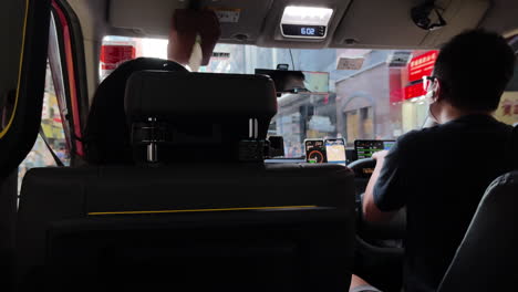 Perspective-view-from-passenger-inside-of-a-taxi-car-driving-on-the-road-in-Hong-Kong,-China