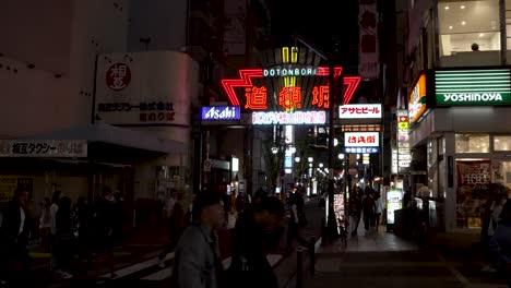 Vergnügungsviertel-Dotonbori-Bei-Nacht-Mit-Beleuchtetem-Straßenschild-Und-Vorbeigehenden-Menschen