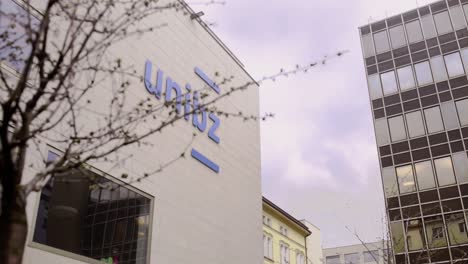 Logo-"unibz"-of-the-Free-University-of-Bolzano-adorning-the-main-facade-of-the-university,-symbolizing-the-institution's-identity-and-academic-excellence