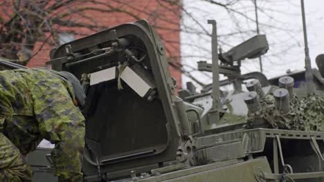 Solider-looking-inside-LAV-6-armored-vehicle-wearing-uniform-on-a-rainy-day