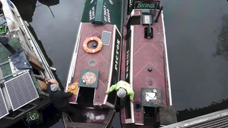 Canal-Boatman-Passing-Over-Wood-Burning-Supplies-To-Customer-On-Regents-Canal-In-Kings-Cross