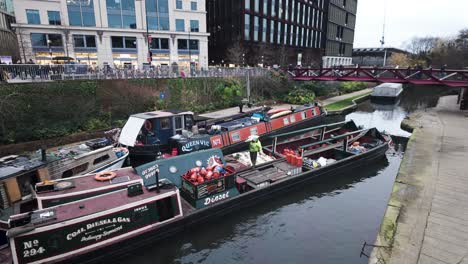 Barquero-Del-Canal-Llevando-Suministros-De-Bolsas-De-Carbón-Para-El-Canal-Regents-Del-Cliente-En-Kings-Cross-Con-El-Puente-Espérance-En-El-Fondo