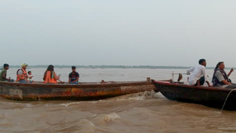 Cinemático-Crucero-Por-El-Río-Ganges-Chowk-Siguiendo-Caída-De-Gente-Canal-Barco-Varanasi-Norte-De-La-India-Estado-Antiguo-Ciudad-Santa-Provincia-De-Ghat-Pradesh-Paisaje-Gris-Nublado-Santo-Fangoso-Marrón-Seguir-Movimiento-A-La-Derecha