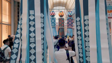 People-in-arcade-walking-through-decorative-paper-streamers-during-Tanabata-festival