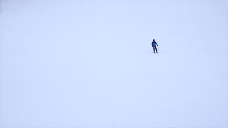 Zeitlupe-Eines-Jungen-Skifahrers,-Der-Einen-Hang-Hinunterfährt,-Während-Einige-ältere-Leute-Vor-Der-Kamera-Die-Strecke-überqueren.-Der-Skifahrer-Wird-Scharf,-Wenn-Er-Näher-An-Die-Kamera-Herankommt