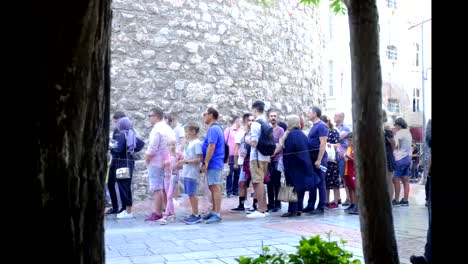 A-group-of-tourists-waiting-for-their-turn-to-enter-the-Galata-Tower-in-Istanbul,-a-photographer-with-time-lapse-photography