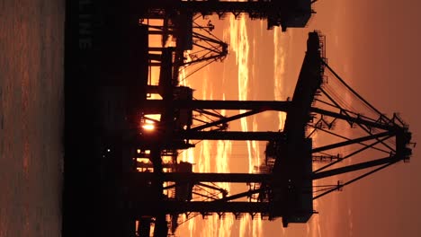 Grúa-De-Contenedores-En-La-Isla-Bukom-En-El-Fondo-Del-Atardecer-Detrás,-Tomada-Desde-El-Embarcadero-De-Labrador