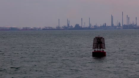 Un-Salvavidas-Flotando-En-Mar-Abierto-Con-La-Vista-De-La-Isla-Bukom-Detrás