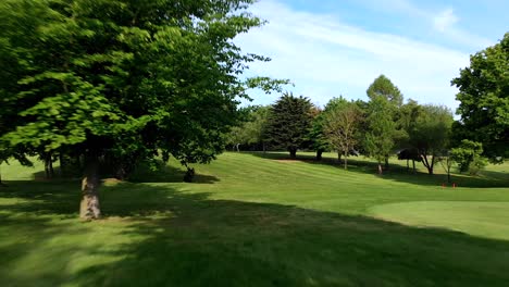 Toma-Aérea-Baja-A-Través-De-árboles-En-Un-Campo-De-Golf-Inglés.