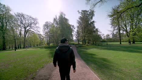 Gimbal-shot-of-Tourist-walking-around-the-park-at-the-Royal-Palace-of-Oslo,-Norway