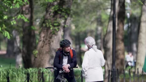 Two-people-having-a-conversation-in-the-park-at-the-Royal-Palace-of-Oslo,-Norway