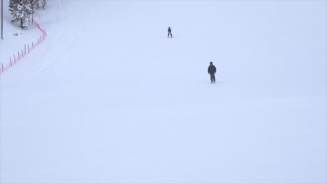 Zeitlupe-Einer-Gruppe-Von-Skifahrern,-Die-An-Einem-Windigen-Tag-Einen-Hang-Hinunterfahren