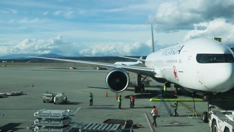 Avión-De-Air-Canada-Estacionado-En-La-Puerta-Con-Trabajadores-De-La-Pista-Hablando-Y-Trabajando.