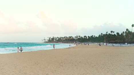 Ein-Blick-Auf-Den-Strand-Mit-Menschen-Während-Des-Sonnenuntergangs