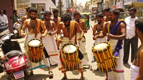 Worshipers-outside-a-Narasimha-Swamy-Hindu-temple-in-Bangalore,-India-preparing-a-shrine-while-musicians-beat-drums